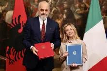 Ein ein Foto von meloni und rama mit einem unterschriebenen Abkommen in ihren Händen