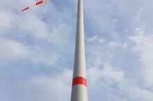 Windrad ragt in einen blauen Himmel mit weißen Wolken