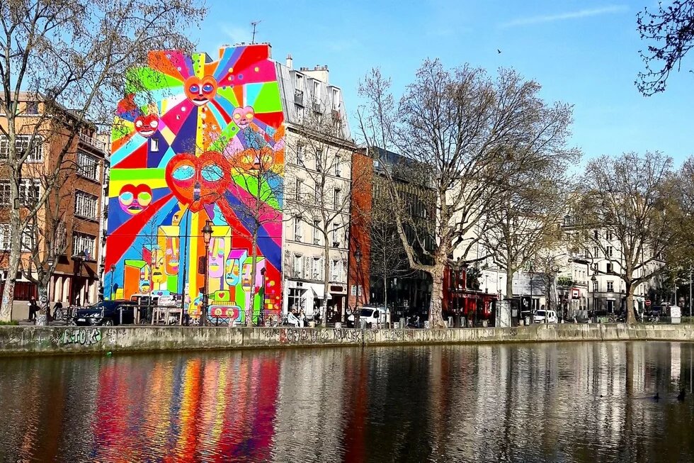 Building of the Paris office of the Heinrich Böll Stiftung. River in front. Behind building with a big colorful graffiti